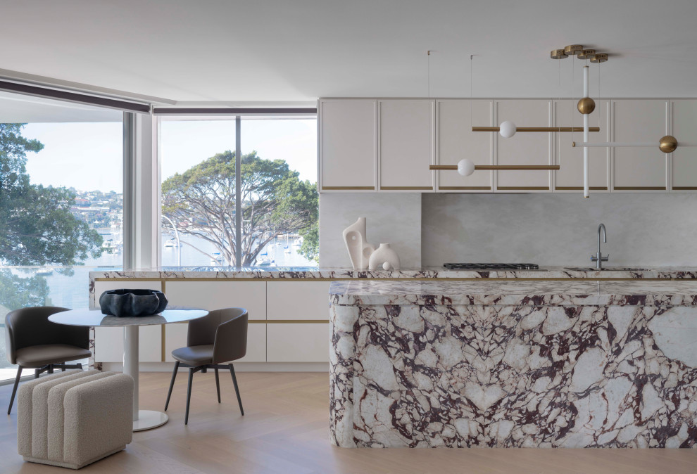 Design ideas for an expansive contemporary kitchen in Sydney with an undermount sink, recessed-panel cabinets, white cabinets, marble benchtops, white splashback, marble splashback, light hardwood floors and with island.