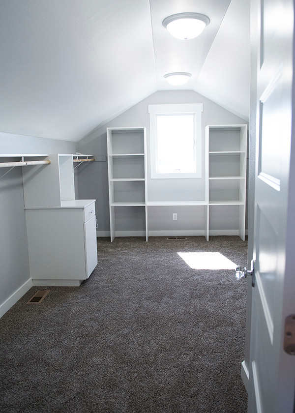 Example of a large transitional gender-neutral carpeted and brown floor walk-in closet design with flat-panel cabinets and white cabinets