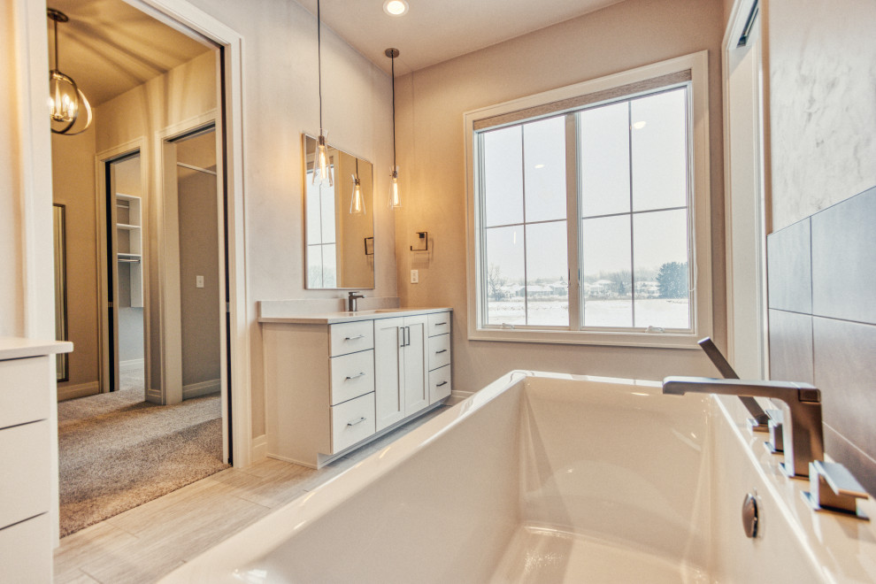 Freestanding bathtub - large transitional master gray tile and ceramic tile ceramic tile and gray floor freestanding bathtub idea with shaker cabinets, white cabinets, an urinal, gray walls, an undermount sink, quartz countertops, a hinged shower door and white countertops