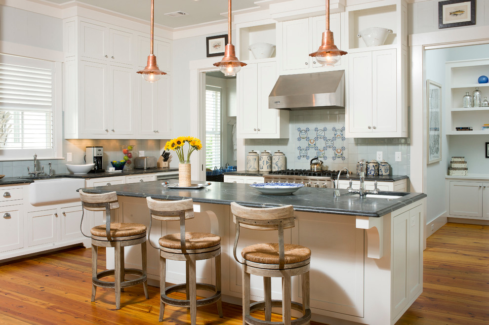 Photo of an industrial l-shaped kitchen in Atlanta with a farmhouse sink, shaker cabinets and white cabinets.