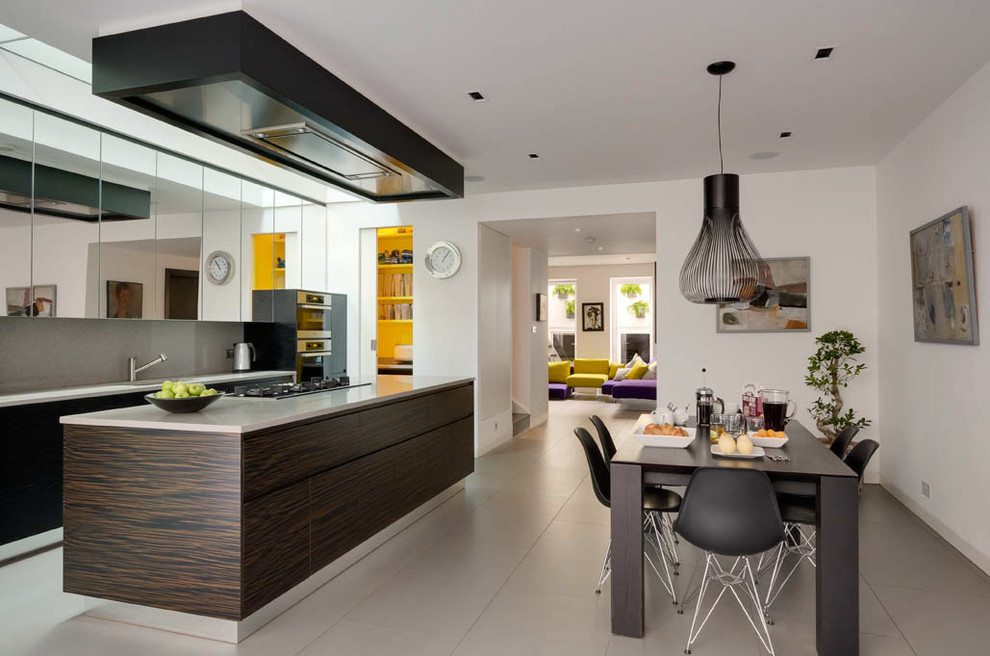 Design ideas for a large contemporary single-wall eat-in kitchen in London with flat-panel cabinets, grey splashback, a drop-in sink, dark wood cabinets, solid surface benchtops, stone slab splashback, stainless steel appliances, cement tiles, with island, grey floor and grey benchtop.