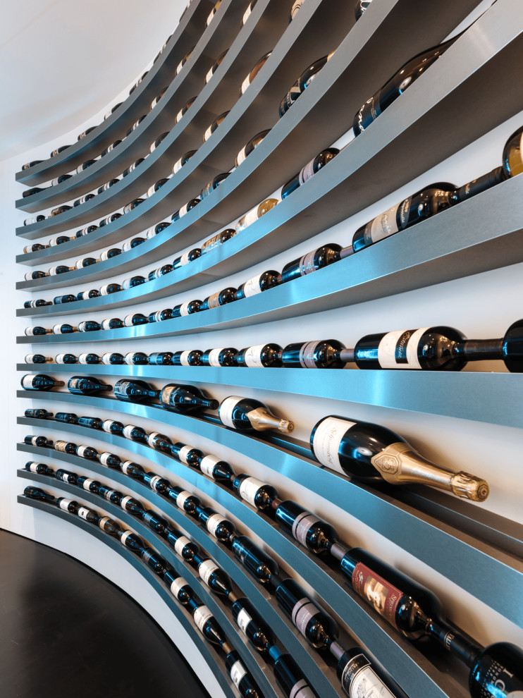 Inspiration for an expansive modern wine cellar in Portland with ceramic floors, display racks and black floor.