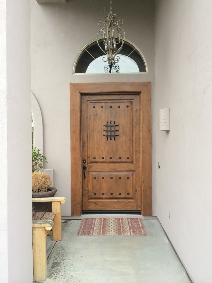 Large mediterranean front door in Phoenix with purple walls, concrete floors, a single front door and a medium wood front door.
