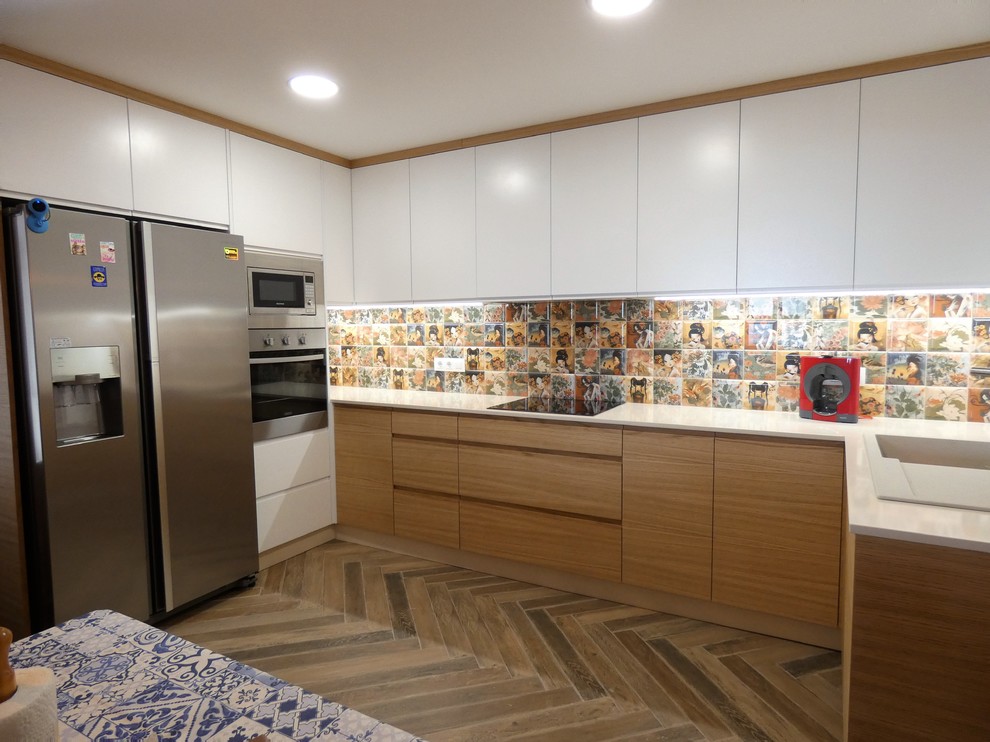Inspiration for a mid-sized modern u-shaped separate kitchen in Alicante-Costa Blanca with a drop-in sink, flat-panel cabinets, light wood cabinets, quartz benchtops, mosaic tile splashback, stainless steel appliances, terrazzo floors and grey floor.