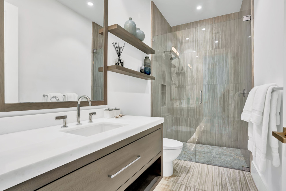 Design ideas for a mid-sized contemporary 3/4 bathroom in Miami with furniture-like cabinets, grey cabinets, an alcove shower, a one-piece toilet, white tile, marble, white walls, marble floors, an undermount sink, marble benchtops, beige floor, a hinged shower door, white benchtops, a niche, a double vanity, a built-in vanity, recessed and wallpaper.