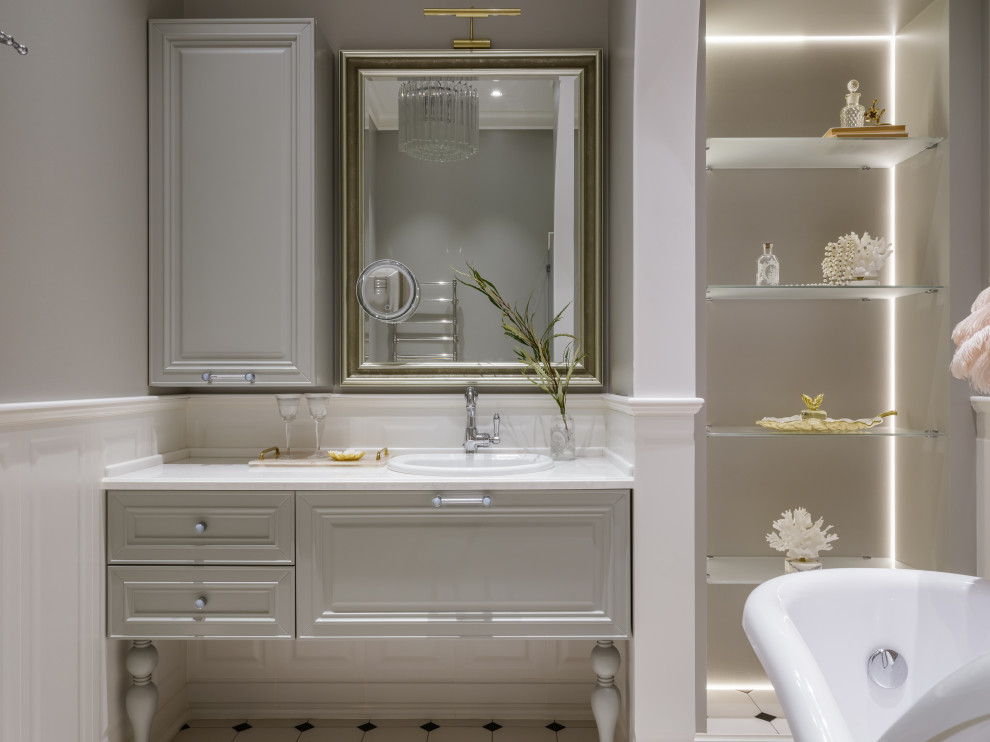 Cette photo montre une salle de bain principale et grise et blanche chic de taille moyenne avec un placard avec porte à panneau encastré, des portes de placard beiges, une baignoire sur pieds, un espace douche bain, un bidet, un carrelage beige, des carreaux de céramique, un mur beige, un sol en carrelage de céramique, un lavabo de ferme, un plan de toilette en marbre, un sol blanc, une cabine de douche à porte battante, un plan de toilette beige, une niche, meuble simple vasque, meuble-lavabo suspendu, un plafond à caissons et du lambris.