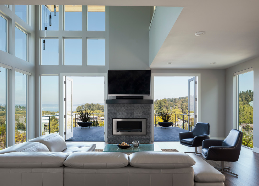 This is an example of a mid-sized contemporary open concept living room in Seattle with white walls, bamboo floors, a standard fireplace and a tile fireplace surround.
