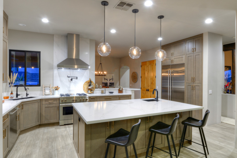 Design ideas for a modern l-shaped kitchen in Phoenix with an undermount sink, shaker cabinets, medium wood cabinets, stainless steel appliances, with island, grey floor and white benchtop.