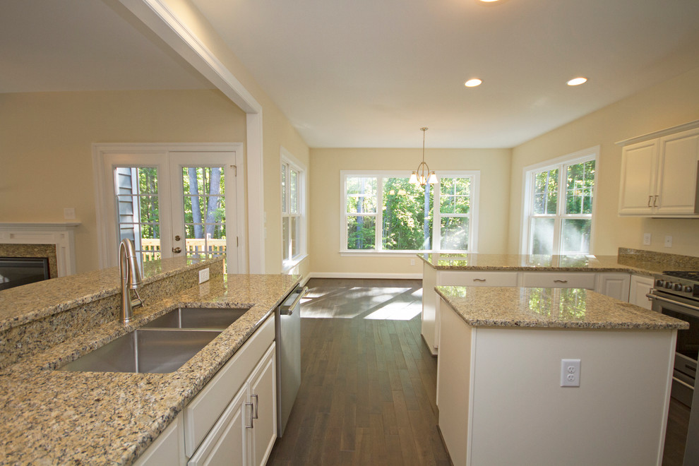 Eat-in kitchen - large transitional u-shaped dark wood floor eat-in kitchen idea in Richmond with a double-bowl sink, raised-panel cabinets, white cabinets, granite countertops, beige backsplash, stainless steel appliances and an island