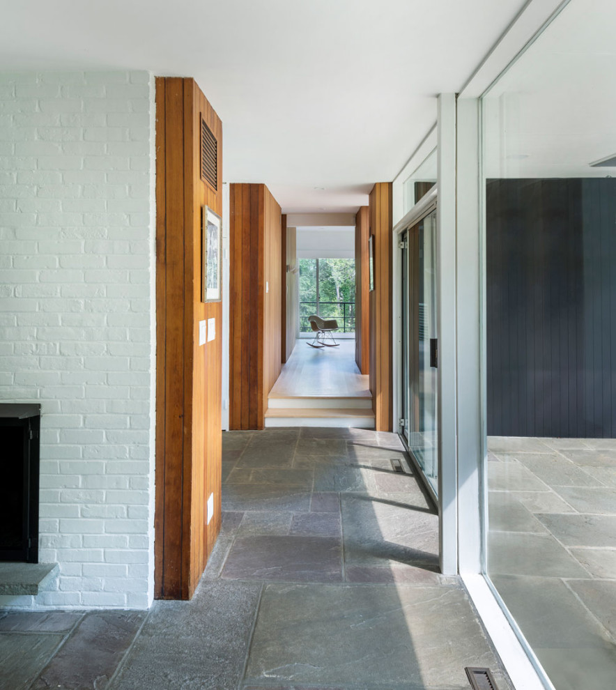 На фото: узкий коридор в стиле ретро с белыми стенами, полом из сланца, серым полом, кирпичными стенами и деревянными стенами