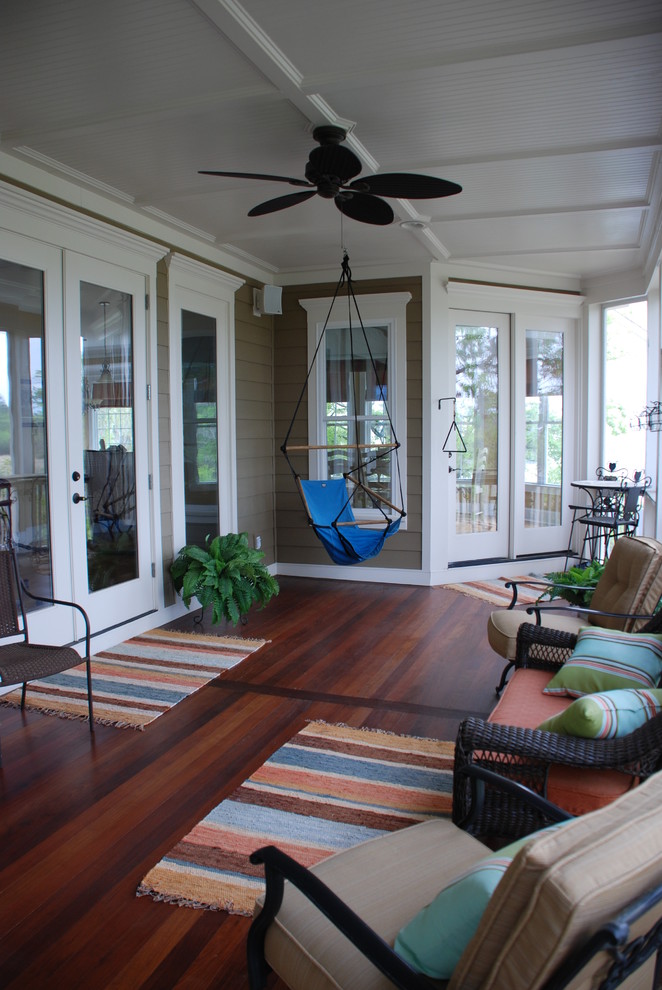 This is an example of a large traditional backyard screened-in verandah in Charleston with a roof extension.