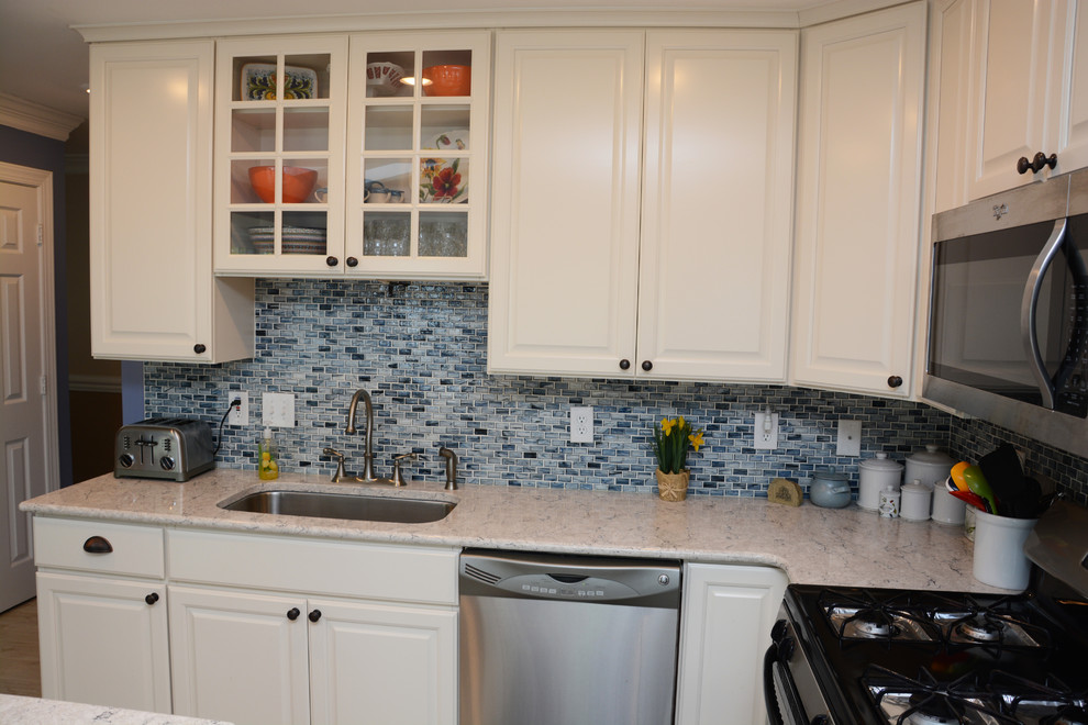 Design ideas for a mid-sized traditional l-shaped eat-in kitchen in DC Metro with a single-bowl sink, raised-panel cabinets, white cabinets, quartz benchtops, blue splashback, stainless steel appliances, with island and white floor.