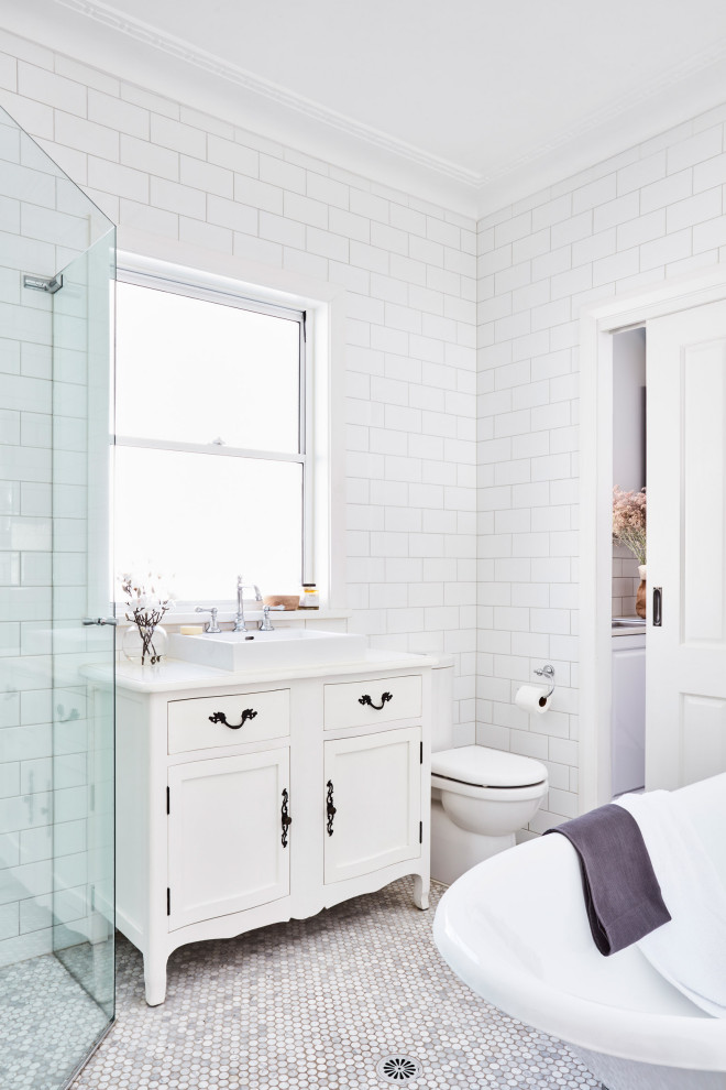 Large transitional master bathroom in Sydney with white cabinets, a freestanding tub, a corner shower, a two-piece toilet, white tile, subway tile, a vessel sink, multi-coloured floor, a hinged shower door, white benchtops and shaker cabinets.