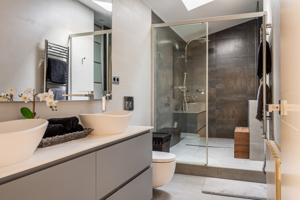 Large contemporary master bathroom in Barcelona with flat-panel cabinets, white cabinets, an alcove shower, a wall-mount toilet, black and white tile, ceramic tile, white walls, ceramic floors, a vessel sink, soapstone benchtops, grey floor, a sliding shower screen, white benchtops, a double vanity, a built-in vanity and vaulted.