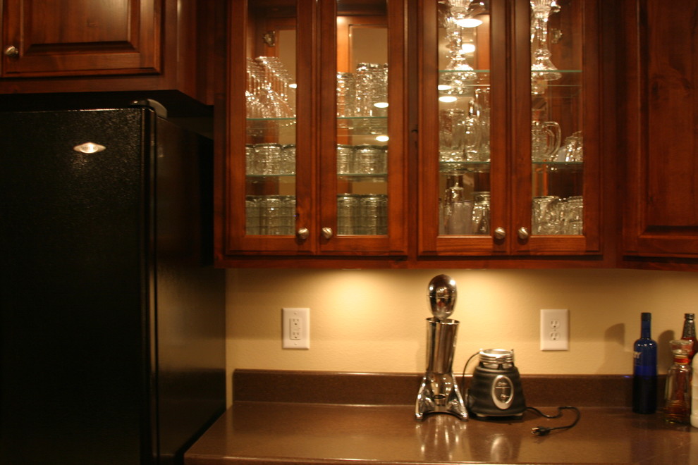 Open concept kitchen - small u-shaped open concept kitchen idea with raised-panel cabinets, dark wood cabinets, black appliances and a peninsula