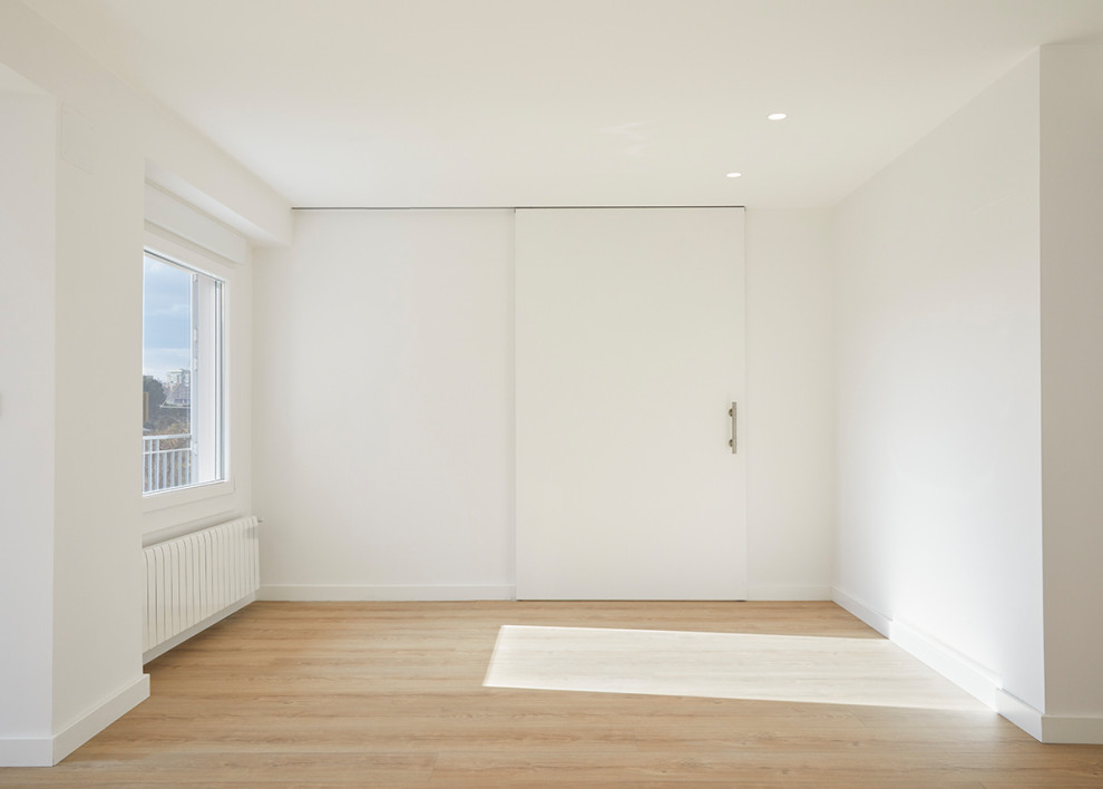 Foto de salón cerrado minimalista grande con paredes blancas, suelo de madera en tonos medios y suelo beige