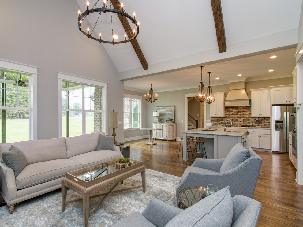 Mid-sized transitional open concept living room in Other with white walls, medium hardwood floors, a standard fireplace, a brick fireplace surround and brown floor.