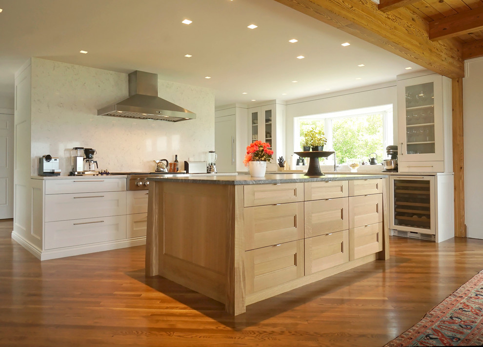 Inspiration for a large transitional l-shaped medium tone wood floor open concept kitchen remodel in Boston with recessed-panel cabinets, white cabinets, white backsplash, stone slab backsplash, stainless steel appliances, an island and a double-bowl sink