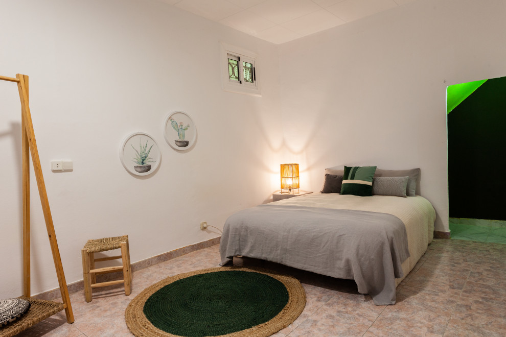 Foto de dormitorio principal y beige y rosa mediterráneo de tamaño medio con paredes blancas y suelo rosa