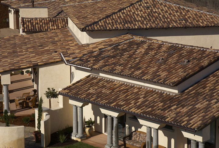 Inspiration for a large mediterranean beige two-story stucco house exterior remodel in San Diego with a hip roof and a tile roof