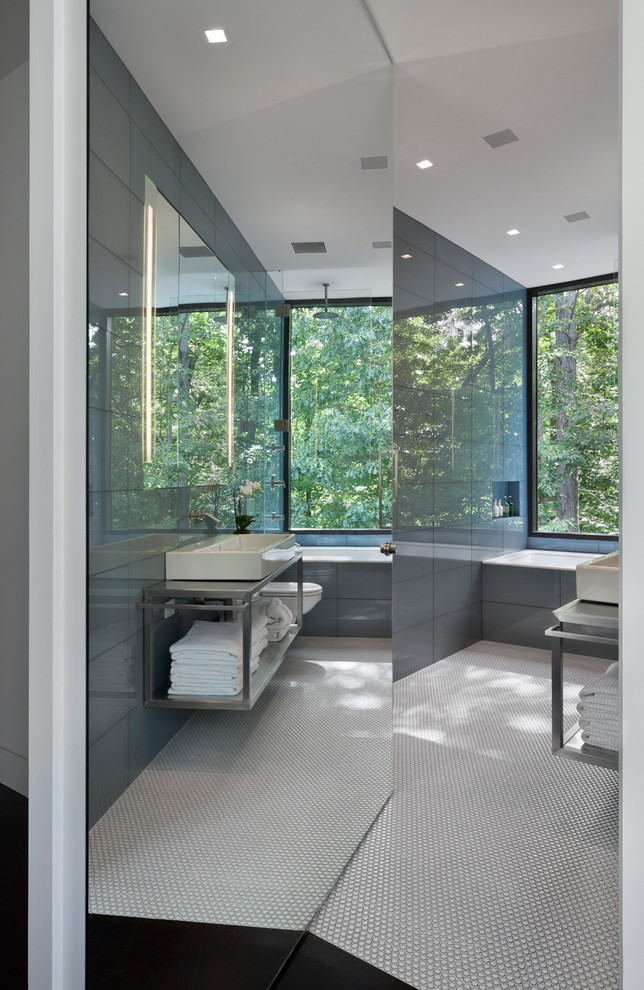 Inspiration for a large modern bathroom in New York with a wall-mount sink, open cabinets, stainless steel benchtops, white walls and dark hardwood floors.