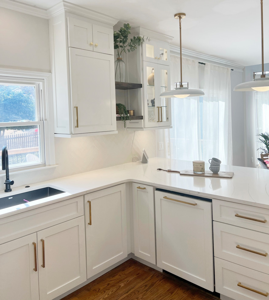 Foto på ett mellanstort vintage grå kök, med en undermonterad diskho, skåp i shakerstil, vita skåp, bänkskiva i kvarts, vitt stänkskydd, stänkskydd i glaskakel, integrerade vitvaror och en halv köksö