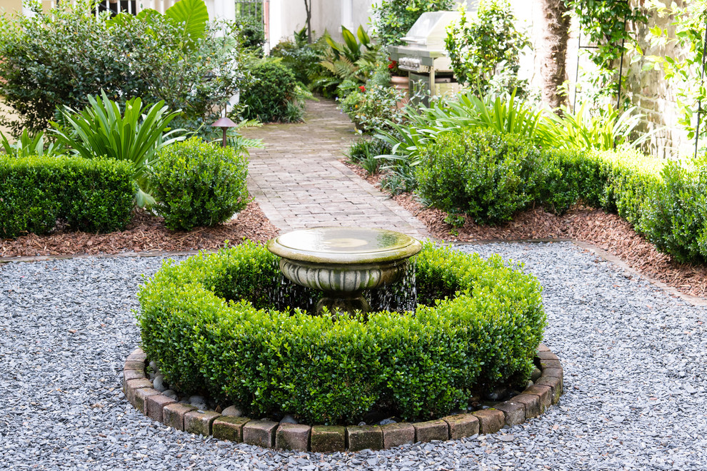 Design ideas for a mid-sized traditional side yard partial sun formal garden for winter in Charleston with a water feature and brick pavers.