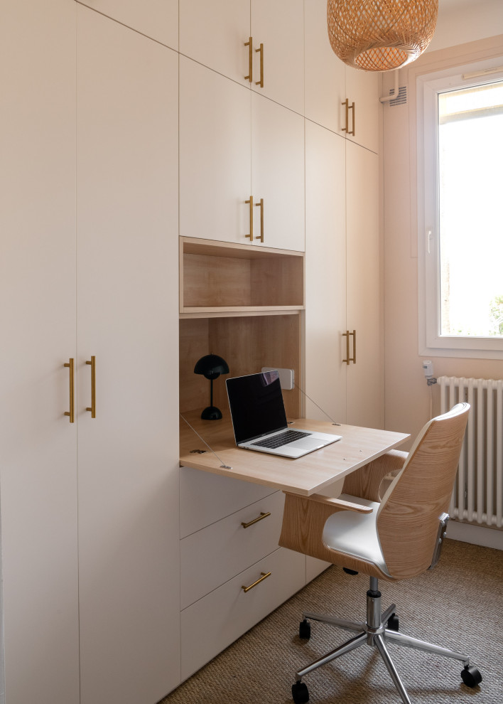 Photo of a mid-sized contemporary study room in Paris with beige walls, carpet, no fireplace, a built-in desk and beige floor.