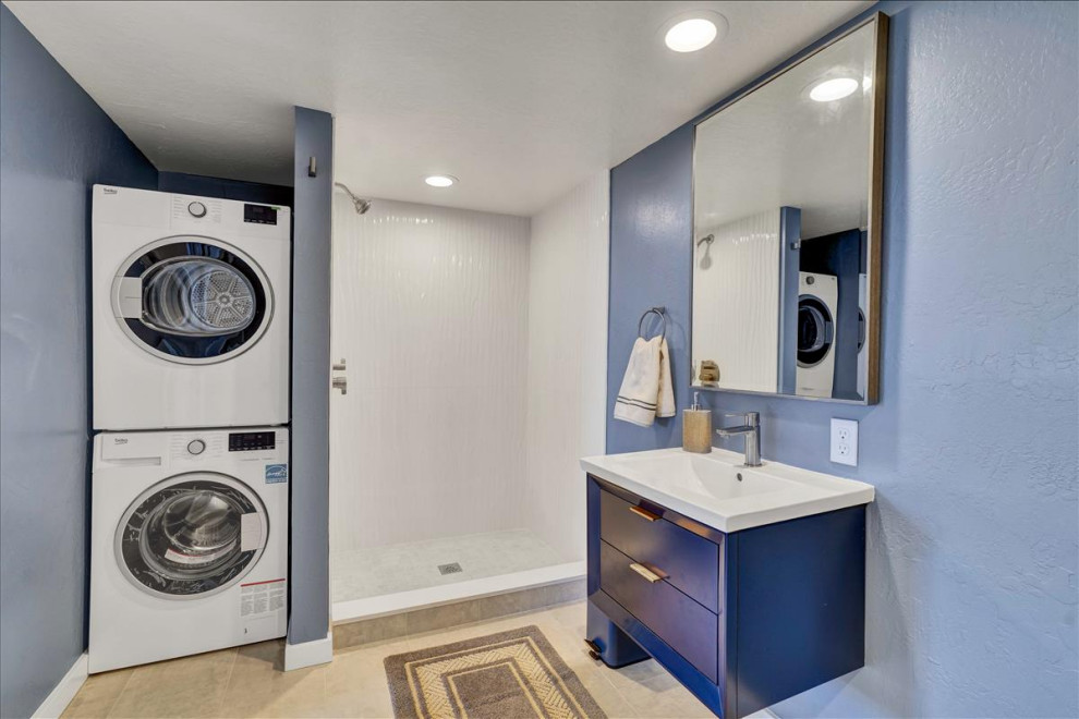 This is an example of a medium sized contemporary family bathroom in San Francisco with shaker cabinets, blue cabinets, an alcove shower, a one-piece toilet, white tiles, ceramic tiles, blue walls, a built-in sink, brown floors, a shower curtain, white worktops, a laundry area, a single sink and a floating vanity unit.