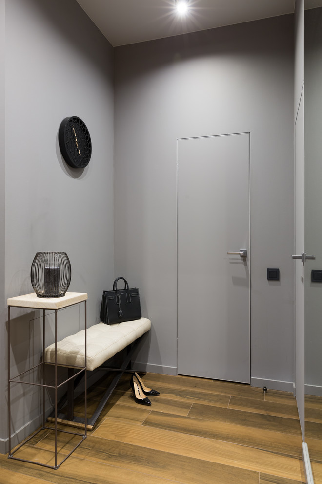 Photo of a small contemporary vestibule in Saint Petersburg with grey walls, porcelain floors and brown floor.