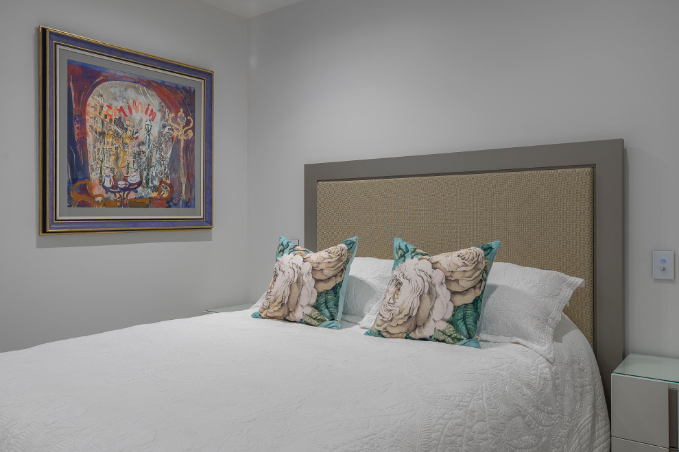 This is an example of a medium sized contemporary guest bedroom in Auckland with grey walls, carpet and beige floors.
