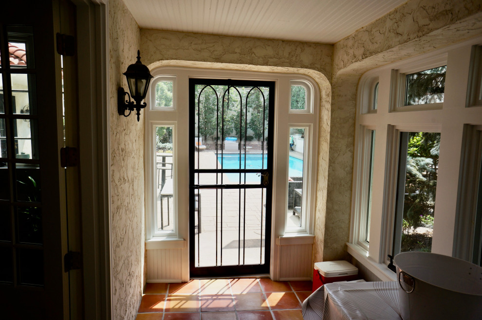 Immagine di un piccolo portico mediterraneo nel cortile laterale con piastrelle