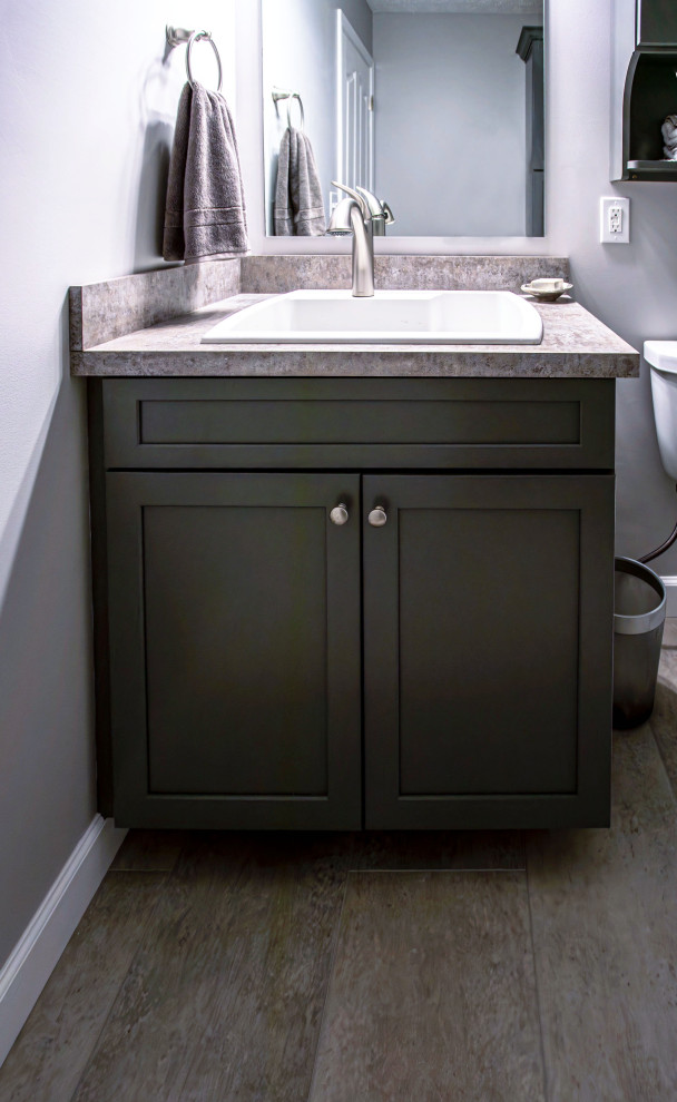 Small transitional powder room in Cleveland with flat-panel cabinets, grey cabinets, a two-piece toilet, grey walls, wood-look tile, a drop-in sink, laminate benchtops, beige floor, beige benchtops and a built-in vanity.