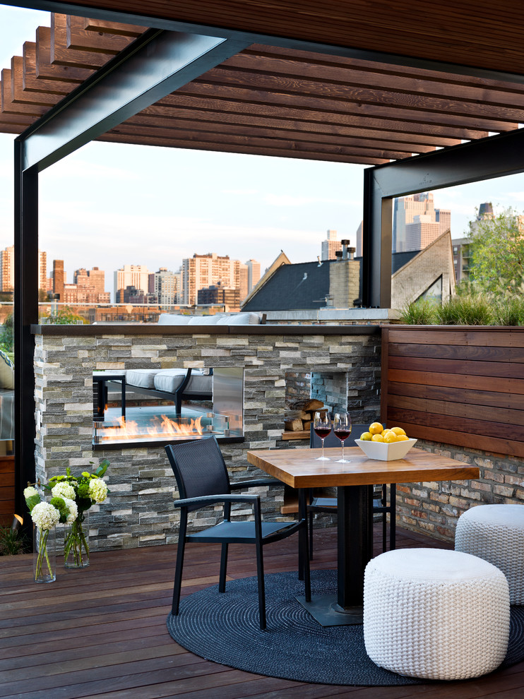 Photo of a mid-sized contemporary rooftop and rooftop deck in Chicago with a fire feature and a pergola.