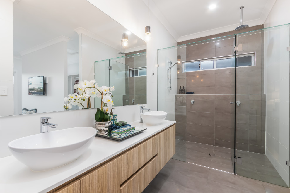 Inspiration for a large beach style 3/4 bathroom in Brisbane with flat-panel cabinets, light wood cabinets, an alcove shower, gray tile, white walls, a vessel sink, grey floor, a hinged shower door, white benchtops, a double vanity and a floating vanity.