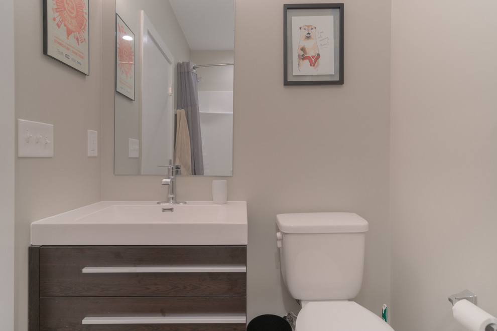 This is an example of a small modern kids bathroom in Other with flat-panel cabinets, medium wood cabinets, an alcove tub, a two-piece toilet, white tile, white walls, vinyl floors, a console sink and brown floor.