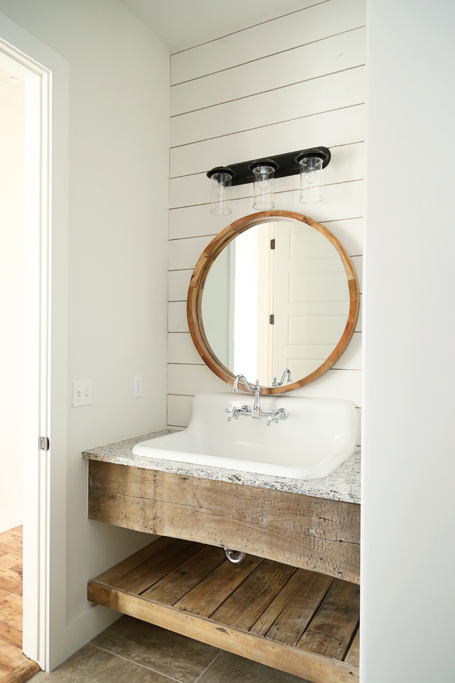 Mid-sized farmhouse powder room photo with white walls, a wall-mount sink, granite countertops and gray countertops
