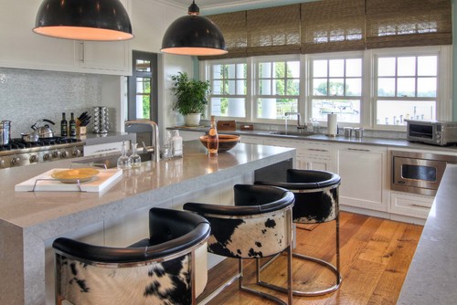 Modern style kitchen featuring cowhide pattern fabrics on the stools which compliment the dark light fixtures