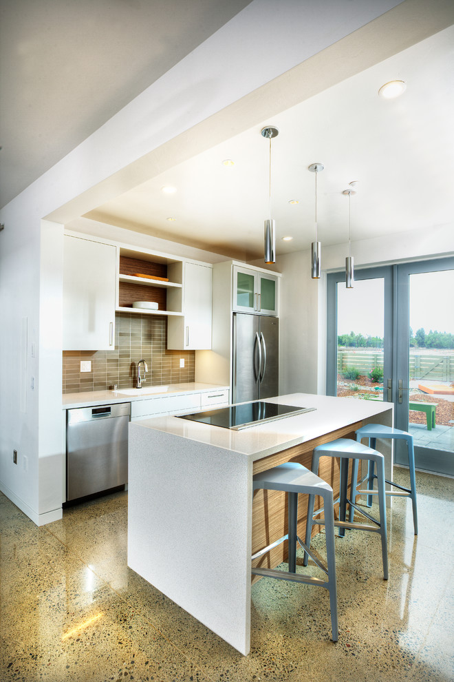 This is an example of a mid-sized contemporary galley open plan kitchen in Sacramento with flat-panel cabinets, white cabinets, grey splashback, stainless steel appliances, with island, an undermount sink, quartz benchtops, glass tile splashback, terrazzo floors and beige floor.