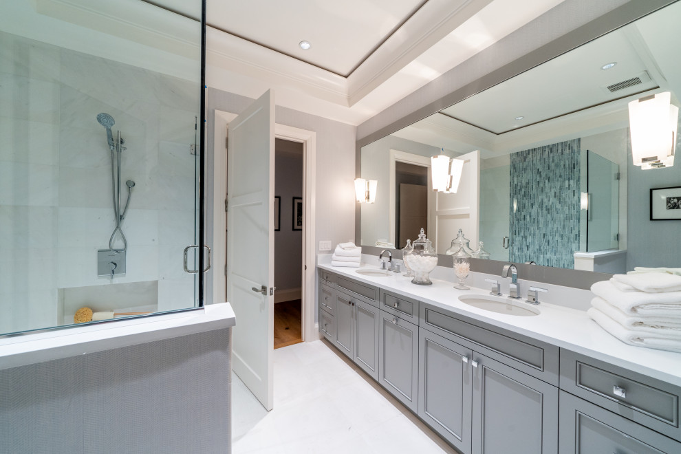 Design ideas for a large transitional master bathroom in Miami with beaded inset cabinets, grey cabinets, an open shower, white tile, porcelain tile, grey walls, porcelain floors, an undermount sink, solid surface benchtops, white floor and white benchtops.