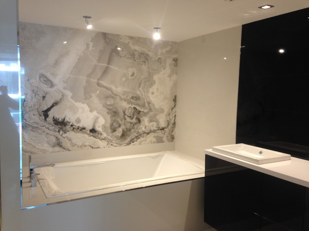 Inspiration for a contemporary bathroom in Miami with gray tile and onyx benchtops.
