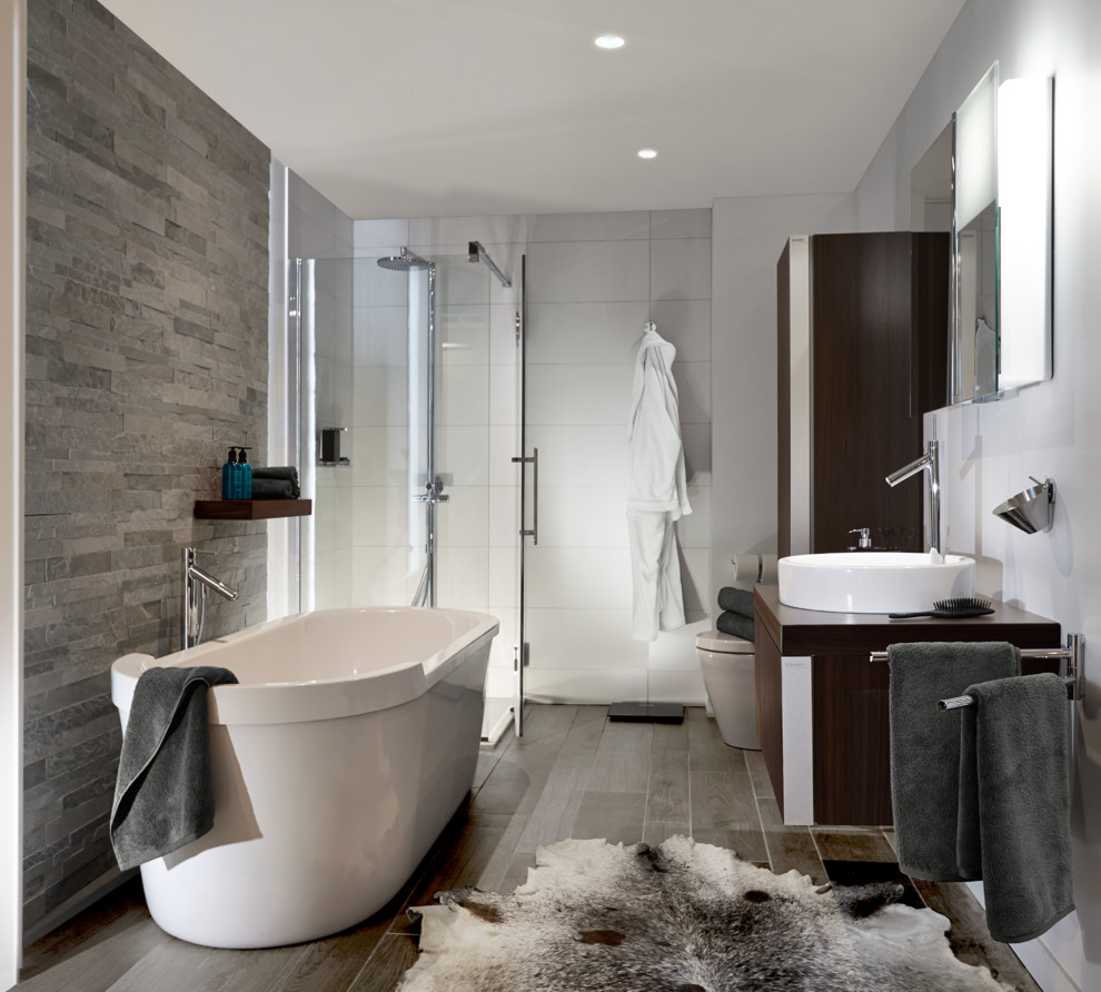 Photo of a large modern master bathroom in Chicago with a freestanding tub, a corner shower, a one-piece toilet, a vessel sink, multi-coloured walls, medium hardwood floors, flat-panel cabinets, dark wood cabinets, stone tile, white tile and wood benchtops.