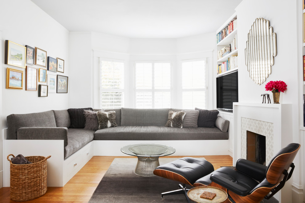 Klassisches Wohnzimmer mit weißer Wandfarbe, Kamin, gefliester Kaminumrandung, braunem Boden, braunem Holzboden und freistehendem TV in San Francisco