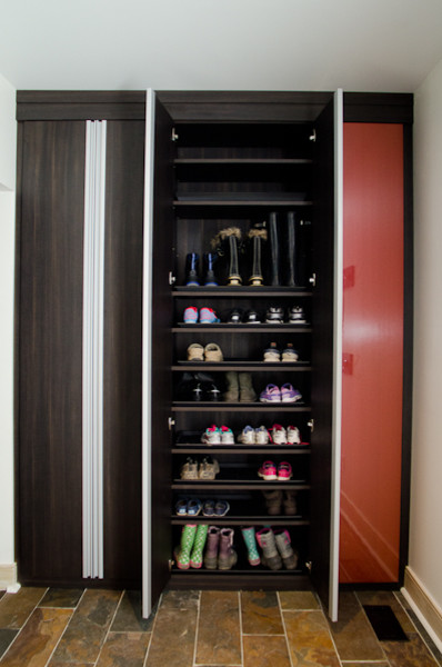 Photo of a large contemporary gender-neutral walk-in wardrobe in Indianapolis with open cabinets, brown cabinets and terra-cotta floors.