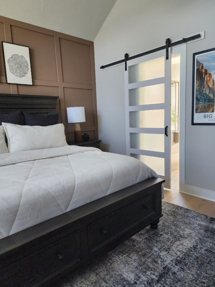 Modelo de dormitorio principal y abovedado tradicional renovado de tamaño medio sin chimenea con paredes marrones, suelo de madera clara y suelo beige