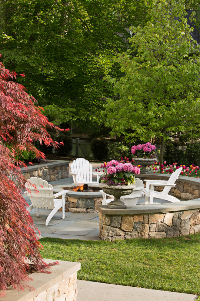 Inspiration for a large traditional backyard patio in New York with natural stone pavers, a fire feature and no cover.