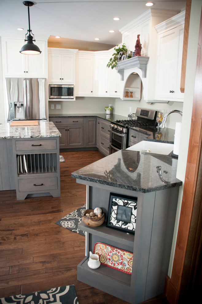 This is an example of a large country u-shaped open plan kitchen in Chicago with a farmhouse sink, flat-panel cabinets, grey cabinets, granite benchtops, stainless steel appliances, dark hardwood floors, with island and brown floor.