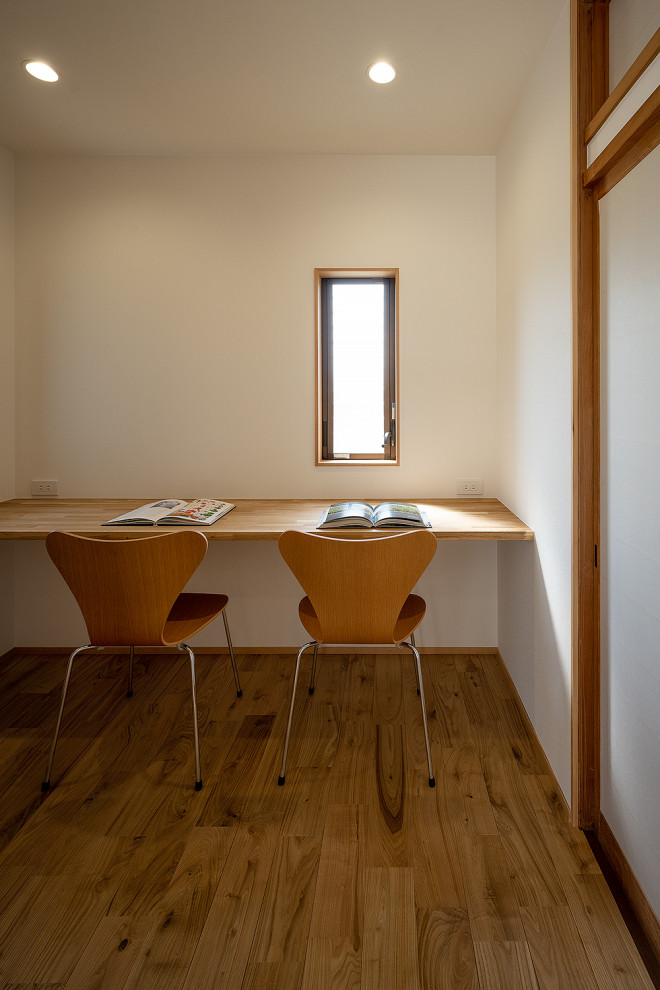 Inspiration för mellanstora skandinaviska hemmabibliotek, med vita väggar, mellanmörkt trägolv, ett inbyggt skrivbord och beiget golv