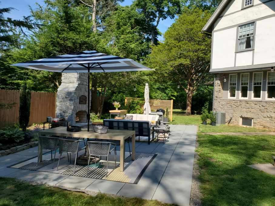Photo of a large transitional backyard patio in New York with with fireplace and natural stone pavers.