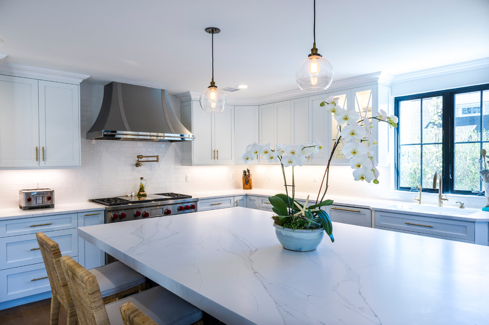 Inspiration for a large modern l-shaped eat-in kitchen in New York with an undermount sink, recessed-panel cabinets, white cabinets, quartz benchtops, white splashback, stainless steel appliances, medium hardwood floors, with island, brown floor and white benchtop.